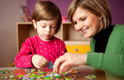 Mother helping daughter with puzzle